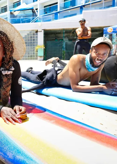 couple of people lying on surf boards in the sand