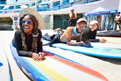 couple of people lying on surf boards in the sand