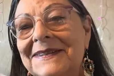 woman with glasses and wearing earrings, smiling