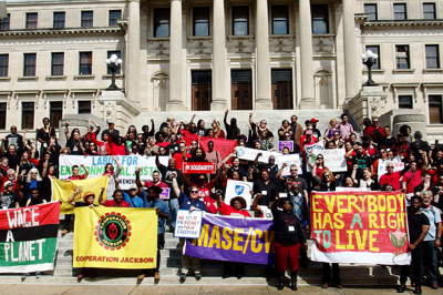 large crowd of people on city capital steps, with banners