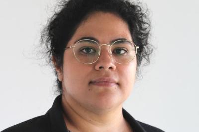 dark her person with glasses, grey blouse, and black blazer