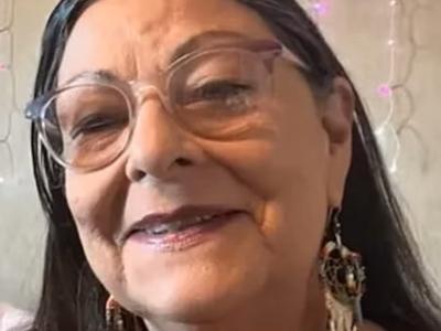 woman with glasses and wearing earrings, smiling