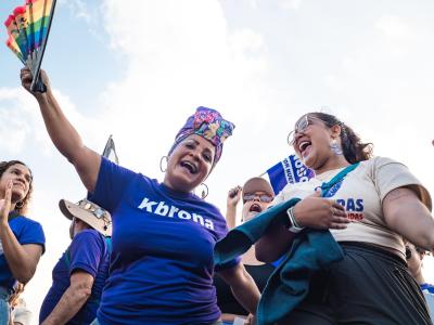 two joyful women cheering in front of a crowd