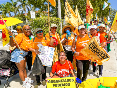 group of people in orange shirts with orange banners