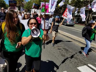 group of people and woman in green shirt with megaphone