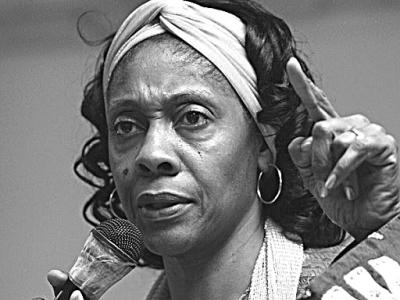 black and white photo of woman with microphone, white headband