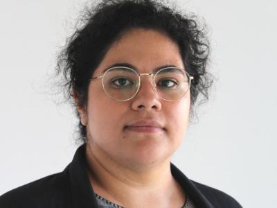 dark her person with glasses, grey blouse, and black blazer