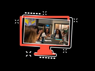 two people in conversation seated at a table, laughing