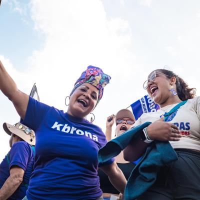 two joyful women cheering in front of a crowd