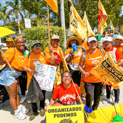 group of people in orange shirts with orange banners